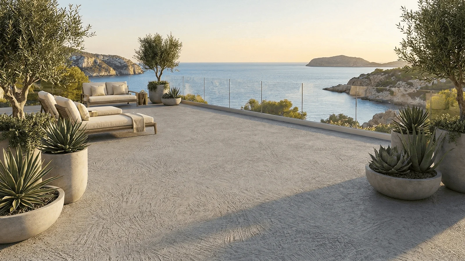 Terrazza panoramica sul mare con pavimento esterno in Rasico grigio, arredi da lounge e grandi vasi con piante mediterranee.